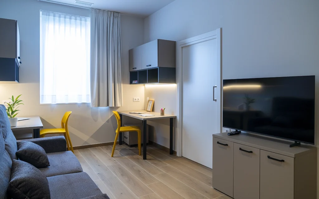 Interior de apartamento con cama, cocina y escritorio en Vitoria-Gasteiz